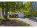 View of a single-Gathering home with a driveway and a manicured front lawn with mature trees at 2375 Lexington Ln, Cumming, GA 30040