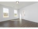 Sunlit living room with hardwood floors, large windows, and a door to the backyard at 121 Chattahoochee Circle, Locust Grove, GA 30248