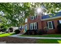 Brick home with a manicured lawn and a bright sunlit view of the front entrance at 165 Mcelwaney Way, Fayetteville, GA 30215
