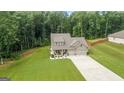Aerial view of a charming home with a spacious lawn, two-car garage, and mature trees at 132 Whitworth Dr # 15, Locust Grove, GA 30248