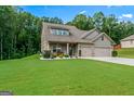 Well-maintained home boasts a lush green lawn and convenient two-car garage at 132 Whitworth Dr # 15, Locust Grove, GA 30248