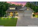 Charming home with a two-car garage, manicured lawn, and inviting front porch at dusk at 132 Whitworth Dr # 15, Locust Grove, GA 30248
