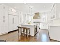 Bright, modern kitchen with white cabinets, stainless steel appliances, an island with seating, and wood floors at 4203 Harrogate Nw Dr, Atlanta, GA 30327