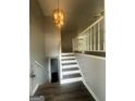 Entryway boasts wood floors, a stairway to an upper level, and a modern chandelier at 8427 Fredericksburg Ct, Jonesboro, GA 30238