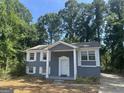 Charming home featuring a painted brick facade, white shutters, and a well-manicured lawn at 8427 Fredericksburg Ct, Jonesboro, GA 30238