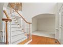 Foyer with white carpeted staircase and wood trim; white walls and hardwood floors at 3688 Eagles Beek Cir, Lithonia, GA 30038