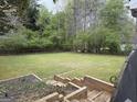 Expansive backyard featuring lush greenery, bordered by trees, and accessible via wooden steps at 362 Mayfield Cir, Alpharetta, GA 30009