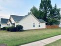 The side view of the home showcases its light yellow siding and dark gray roof at 486 Village Cir, Stockbridge, GA 30281