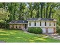 Charming two-story home with brick accents, a well-manicured lawn, and mature trees surrounding the property at 5802 Simone Dr, Stone Mountain, GA 30087
