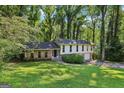 Charming two-story home with brick accents, a well-manicured lawn, and mature trees surrounding the property at 5802 Simone Dr, Stone Mountain, GA 30087