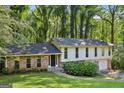 Charming two-story home with brick accents, a well-manicured lawn, and mature trees surrounding the property at 5802 Simone Dr, Stone Mountain, GA 30087
