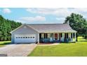 Charming single-story home with a welcoming front porch, attached garage, and well-manicured lawn at 1042 Harbins Rd, Dacula, GA 30019