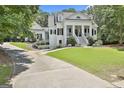 Stunning white home showcasing a columned porch, a long driveway, and verdant surroundings at 275 Sidney Ln, Fayetteville, GA 30215