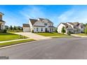 A well-maintained neighborhood street showcasing a two-story white home with an attached garage at 604 Francis Ave, Peachtree City, GA 30269