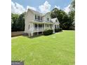 Spacious home with a covered porch, set on a large lot with mature trees, offering a serene and private living experience at 60 Grange Ct, Sharpsburg, GA 30277
