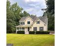 Inviting two-story home with a classic design, featuring a front porch perfect for relaxing and enjoying the landscaped yard at 60 Grange Ct, Sharpsburg, GA 30277