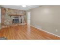 Inviting living room boasts a stone fireplace and gleaming hardwood floors at 100 Homestead Pl, Rex, GA 30273