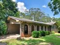 The back exterior of the brick home featuring a covered carport and arched porch at 100 Homestead Pl, Rex, GA 30273
