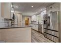 Modern kitchen with white cabinets, stainless steel appliances, granite countertops, and gray flooring at 315 Charlotte Blvd, Stockbridge, GA 30281