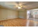 Bright, empty living room featuring wood floors and a ceiling fan, leading into an adjacent kitchen at 315 Charlotte Blvd, Stockbridge, GA 30281