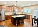 Spacious kitchen boasts a central island, stainless steel appliances, granite countertops, and hardwood floors at 9108 Alden Dr, Locust Grove, GA 30248