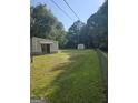 View of the expansive backyard showing the home, storage shed, and perimeter fence at 85 North Ave, Hampton, GA 30228