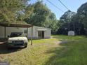 Exterior view with covered parking, ample yard space, and additional shed for storage at 85 North Ave, Hampton, GA 30228