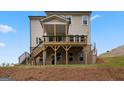 Rear view of home featuring a raised deck with stairs down to the yard and a walkout basement at 7530 W Homer Dr, Cumming, GA 30028