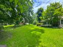 Picturesque property featuring a well-maintained lawn, mature trees, and a cozy home with charming details at 4160 Stonewall Tell Rd, Atlanta, GA 30349