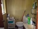 Small, outdated half-bathroom with patterned wallpaper and vanity at 6553 Port A Prince Dr, Forest Park, GA 30297