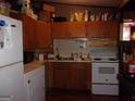 Dated kitchen featuring wood cabinets, laminate countertops, and a white appliance package at 6553 Port A Prince Dr, Forest Park, GA 30297
