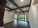 Spacious living room with coffered ceiling, hardwood floors, and sliding doors to screened porch at 987 Kora Sw Dr, Marietta, GA 30064