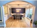 Formal dining room features hardwood floors, wainscoting and a stylish light fixture at 910 Lilac Arbor Rd, Dacula, GA 30019