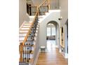 Elegant foyer features hardwood floors, staircase with iron railings, and arched doorways at 910 Lilac Arbor Rd, Dacula, GA 30019