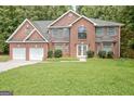 Charming two-story brick home with a well-manicured lawn and attached two car garage at 204 Eleanor Court, Stockbridge, GA 30281