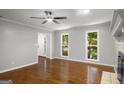 Light-filled living room featuring a ceiling fan, hardwood floors, and two windows at 1783 Cheyenne Trl, Jonesboro, GA 30236