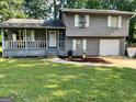 Charming two-story home with a covered porch and a well-manicured lawn at 55 Porter Cir, Hampton, GA 30228