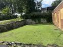 A yard with a stone retaining wall shows signs of neglect and overgrowth at 1175 Monroe Ne Dr, Atlanta, GA 30306