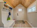 Mud room entryway featuring a white bench, hooks for coats, light wood flooring, and a wood plank ceiling at 480 Mitchell Rd, Covington, GA 30014
