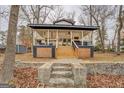Charming exterior of home featuring a cozy front porch with outdoor seating, stairway to the front door, and wooded surroundings at 480 Mitchell Rd, Covington, GA 30014