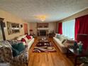Spacious living room featuring a brick fireplace, hardwood floors, and large windows at 4402 Auburn Hills Drive, Stone Mountain, GA 30083