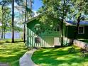 Side view of home with mature trees, lush grass, and a walkway at 3106 Jodeco Dr, Jonesboro, GA 30236