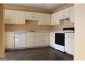 Bright kitchen features white cabinets, modern appliances, and sleek dark floors at 2116 Charter Ln, Lithonia, GA 30058