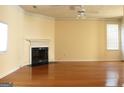 Spacious living room with hardwood floors, a cozy fireplace, and a ceiling fan at 2116 Charter Ln, Lithonia, GA 30058
