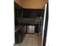 Compact kitchen featuring sleek black cabinetry, stainless steel appliances, and granite countertops at 3060 Nw Pharr Ct # 517, Atlanta, GA 30305