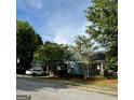 View of the side of the house, with a car parked on the driveway and mature trees in the background at 75 Orchard Dr, Covington, GA 30014