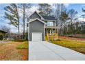 Charming two-story home with gray siding, a front porch, manicured lawn, and an attached garage at 192 Pecan Dr, Canton, GA 30114