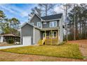 Charming two-story home with gray siding, a front porch, manicured lawn, and an attached garage at 192 Pecan Dr, Canton, GA 30114