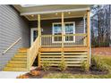 Inviting front porch with wood columns and railings, complemented by newly installed stairs and landscaping at 192 Pecan Dr, Canton, GA 30114