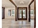Elegant foyer featuring a modern chandelier, a front door with glass inserts, and light gray floors at 2255 Buford Dam Rd, Buford, GA 30518